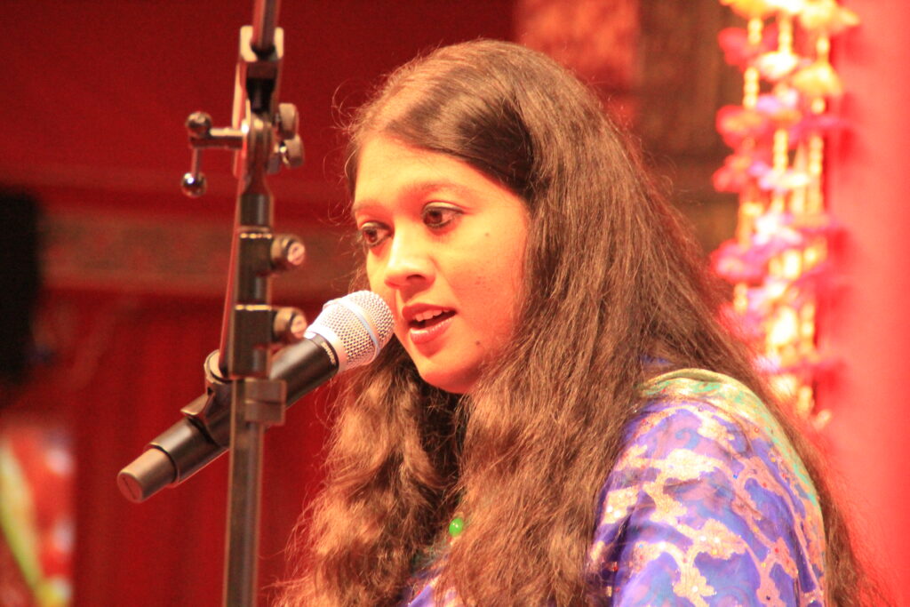 Close view of Mouli Chakrabarti singing into a microphone in Kassel.